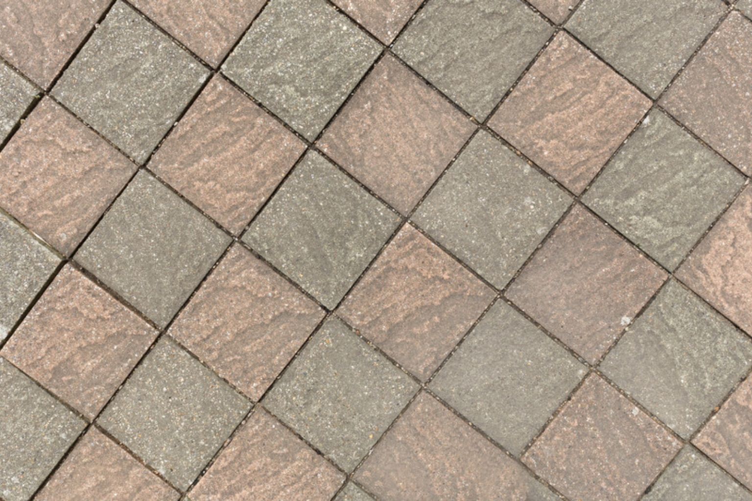 Grå og rødlige betonfliser lagt diagonalt i et ternet mønster